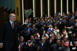 Turkey's President Recep Tayyip Erdogan, holding an olive branch arrives to deliver a speech at an event in Ankara, Turkey, Feb. 20, 2018.