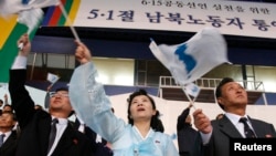 지난 2007년 5월 한국 창원에서 열린 6.15 공동선언 실천을 위한 남북노동자 행사에서 북한 측 대표들이 한반도 전체지도가 그려진 깃발을 흔들고 있다. (자료사진)