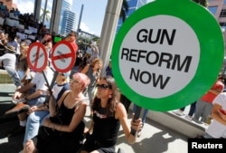 Protesters hold signs as they call for a reform of gun laws three days after the shooting at Marjory Stoneman Douglas High School, at a rally in Fort Lauderdale, Florida, Feb. 17, 2018.