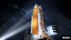 This illustration shows NASA’s new rocket, the Space Launch System (SLS), in its Block 1 crew vehicle setup that will send astronauts to the Moon on the Artemis missions. For the rocket’s first flight on the Artemis I mission, it will send an uncrewed Orion spacecraft in an orbit beyond the Moon. (Image Credit: NASA)