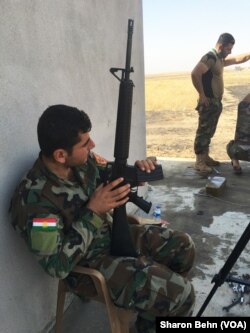 Iraqi Kurdish Peshmerga fighter outside a house recently recaptured from IS extremists on the Mosul frontline.