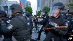 Seattle Police officers move in to make an arrest, May 1, 2017, during a May Day protest in Seattle. 