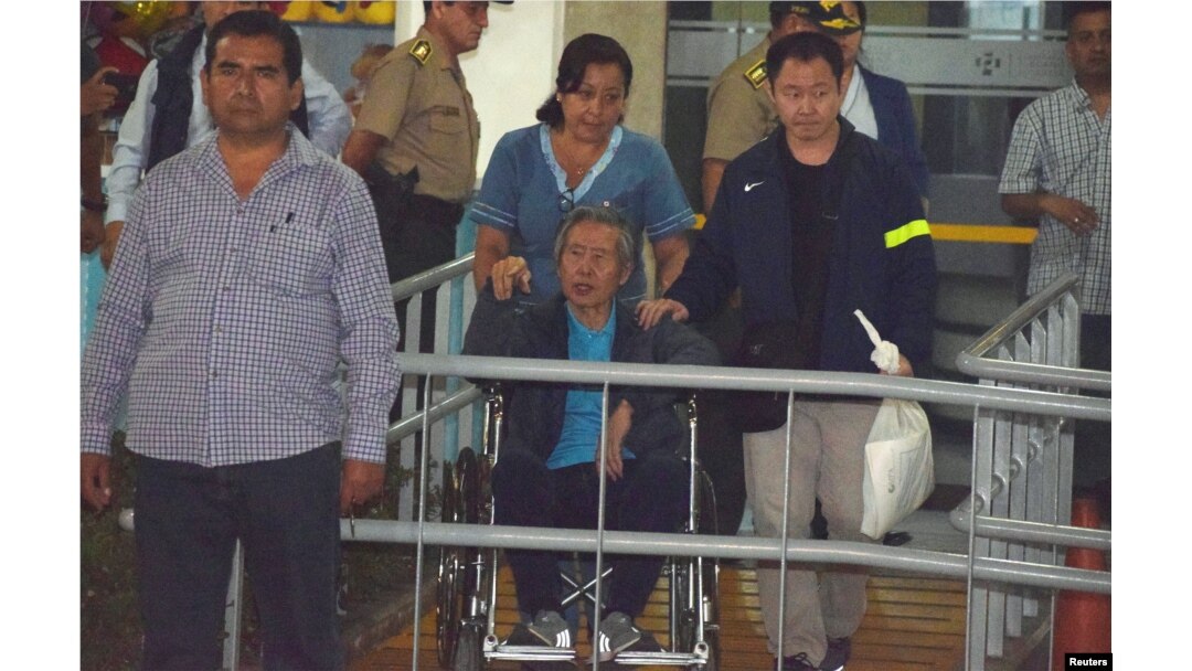 Former Peruvian President Alberto Fujimori, center, accompanied by his son Kenji Fujimori, right, leaves the Centenario hospital in Lima, Peru, Jan. 4, 2018.