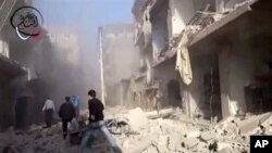 Warga Suriah memberikan pertolongan darurat untuk orang-orang yang terluka akibat serangan udara yang dilancarakan oleh pemerintah Suriah di daerah pemukiman penduduk di pinggiran kota Damaskus, 14 Januari 2013. (AP Photo/Shaam News Network via AP video)