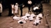 FILE: Medical workers at Beijing's Fuxingmen Hospital look at bodies of protesters killed by soldiers around Tiananmen Square on June 4, 1989.