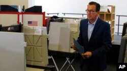 Gov. Dannel P. Malloy prepares to submit his ballot for the primary election at a polling place in Hartford, Connecticut, Aug. 14, 2018.