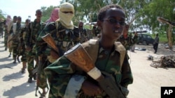 FILE - A youth leads a group of hard-line Islamist al-Shabab fighters as they conduct military exercises in northern Mogadishu's Suqaholaha neighborhood, Somalia, Jan. 1, 2010. 