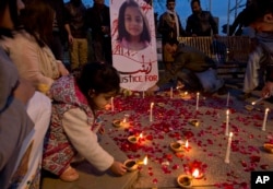 A Pakistani girl lights a candle during a memorial for Zainab in Islamabad, Jan. 11, 2018. Zainab's father, Mohammed Amin Ansari, denounced police for failing to warn residents about a serial killer in the city.