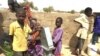 Des enfants réfugiés à l'une des fontaines d'eau du camp de Dar Es Salam à Baga-Sola (ouest du Tchad).