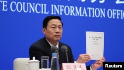 Guo Weimin, Vice Director of the Information Office of China's State Council holds a white paper titled “China’s Position on the China-US Economic and Trade Consultations” at a news conference in Beijing, June 2, 2019. 
