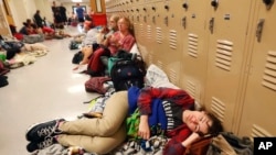 Emily Hindle lies on the floor at an evacuation shelter set up at Rutherford High School, in advance of Hurricane Michael, which made landfall, in Panama City Beach, Fla., Oct. 10, 2018.