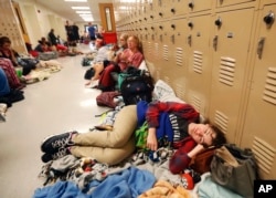Emily Hindle lies on the floor at an evacuation shelter set up at Rutherford High School, in advance of Hurricane Michael, which made landfall, in Panama City Beach, Fla., Oct. 10, 2018.