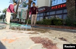 Cleaners try to clean blood stains near the entrance to Bella Vista Hotel in the Red Sea resort of Hurghada, Egypt, Jan. 9, 2016.