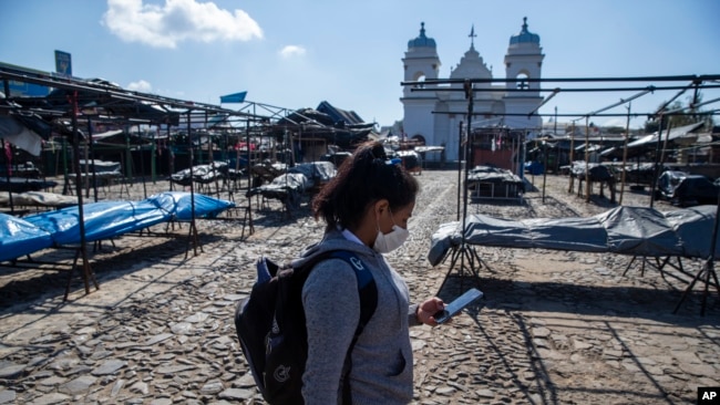 Una mujer usa una máscara facial como precaución contra la propagación del nuevo coronavirus en el desierto mercado de San Martín Jilotepeque, en Guatemala, el viernes 20 de marzo de 2020.