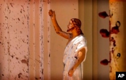 Blood stains are seen on the wall and on a Jesus Christ statue at the St. Sebastian's Church after blast in Negombo, north of Colombo, Sri Lanka, Sunday, April 21, 2019.