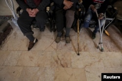 Men with amputated limbs wait to be inspected in the rebel-controlled area of Maaret al-Numan town in Idlib province, Syria, March 20, 2016.