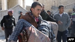 A man carries a body following a reported Syrian government forces air strike in the northern city of Aleppo on Feb. 4, 2014. 