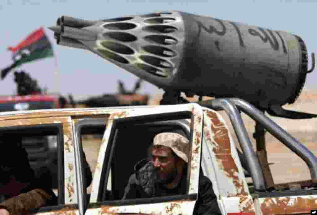 A rebel sits inside a pick-up truck mounted with a helicopter rocket launcher at the western gate of the strategic town of Ajdabiya on April 23, 2011. Intense fighting gripped Misrata overwhelming its hospital with casualties after Moammar Gadhafi's regim