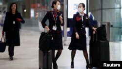 جاپان ایئرلائنز کی ایئر ہوسٹس ماسک پہنے ہوئے ہیں۔ کمپنی نے انہیں سکرٹ کی بجائے پتلون اور بغیر ہیل کے جوتے پہننے کی اجازت دے دی ہے۔