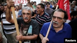 Greek protesters shout slogans as they march during a rally against the visit of the German Finance Minister Wolfgang Schaeuble in Athens, July 18, 2013. 