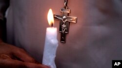 FILE - A Pakistani nun holds a candle during a vigil for victims of a deadly suicide bombing in a park, March 28, 2016, in Lahore. Pakistan's prime minister has vowed to eliminate perpetrators of mass terror attacks.