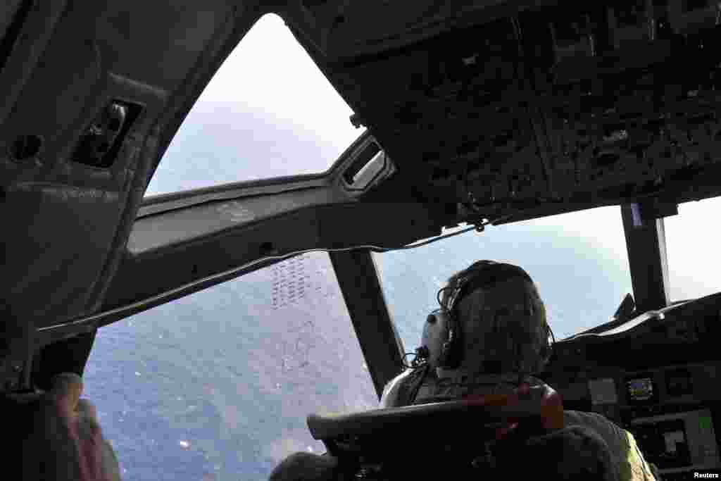 A crew member sits in the cockpit of a Royal New Zealand Air Force patrol aircraft as it continues searching in the southern Indian Ocean for Flight MH370, April 1, 2014.