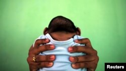 Jackeline, 26 anos, e seu bebé nascido com micocefalia, em Olinda, Recife, Brasil, 2016. 