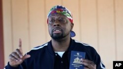 Atis Ayisyen Wyclef Jean pale ak fanmi migran yo nan yon sant pou migran nan vil Tijuana, peyi Meksik, 27 Oct. 2021.