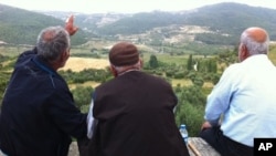 Residents of Güveççi, Turkey, look across the valley to Syria, June 11 2011