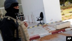 Polisi menjaga pintu masuk Museum Bardo di Tunis, Tunisia (19 Maret 2015), sehari setelah pria-pria bersenjata melepaskan tembakan, menewaskan 21 orang. (AP/Christophe Ena)