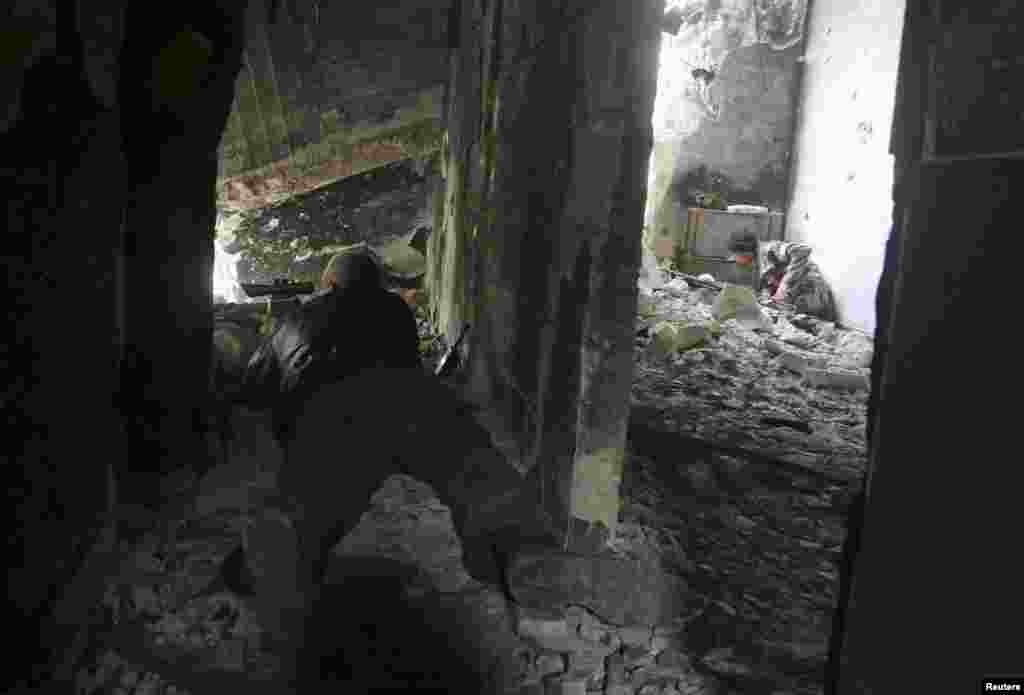 Rebel fighters aim their weapons at forces loyal to Syria's President Bashar al-Assad in Maysaloun neighborhood in the old city of Aleppo.