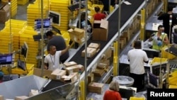 FILE - Workers sort arriving products at an Amazon Fulfilment Center in Tracy, California, August 3, 2015.