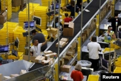 FILE - Workers sort arriving products at an Amazon Fulfillment Center in Tracy, California, Aug. 3, 2015.