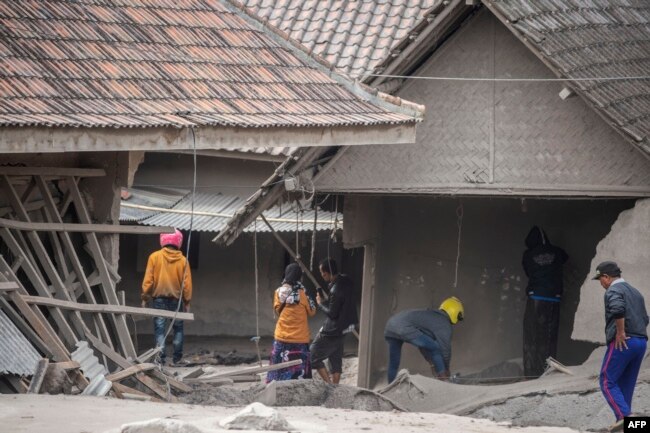 Petugas penyelamat melakukan pencarian warga di daerah yang tertutup abu vulkanik di Desa Sumber Wuluh di Lumajang pada 5 Desember 2021, setelah letusan Gunung Semeru yang menewaskan sedikitnya 13 orang. (Foto: AFP/Juni Kriswanto)