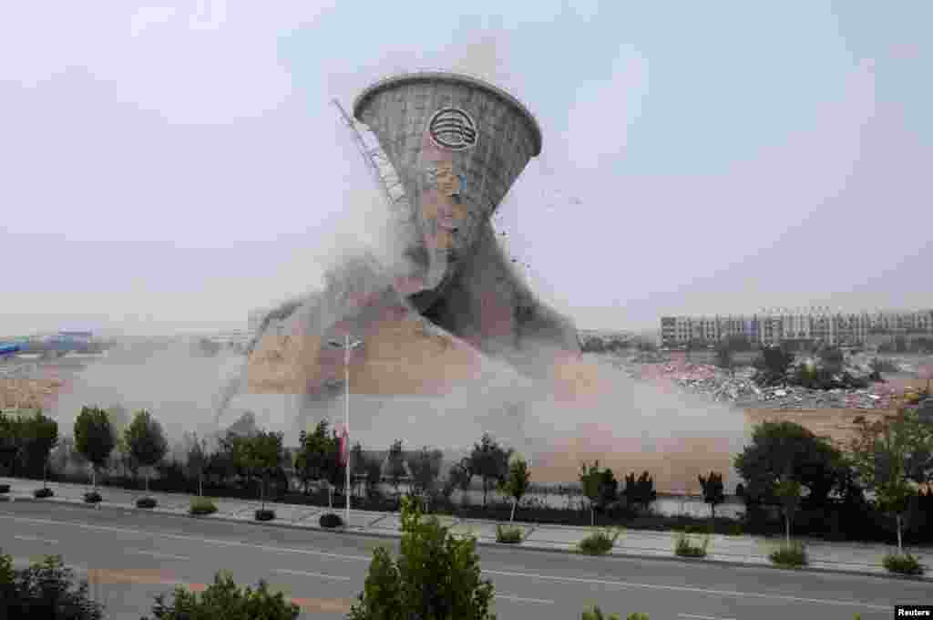 A cooling tower is seen under mechanical demolition in Binzhou, Shandong Province, China, July 13, 2016.