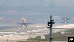 FILE - Turkish Air Force fighter planes land at Incirlik Air Base, on the outskirts of the city of Adana, southern Turkey, Thursday, July 30, 2015.