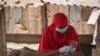 Une vendeuse de Khat porte un masque et des gants pour empêcher la propagation du coronavirus à Djibouti, le 26 mars 2020.