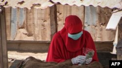 Une vendeuse de Khat porte un masque et des gants pour empêcher la propagation du coronavirus à Djibouti, le 26 mars 2020.