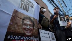 Activists hold photos of Thai dissident Wanchalearm Satsaksit gather for a rally in front of the Cambodian Embassy in Bangkok, Thailand, Monday, June 8, 2020. (AP Photo/Sakchai Lalit)