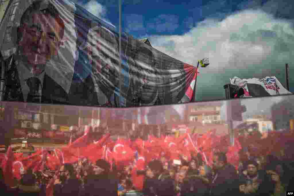 A reflection on a election bus window shows supporters of Turkey&#39;s Justice and development Party (AKP) during an election rally in Istanbul.
