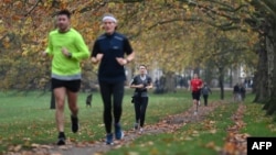 People exercise in Green Park in central London on November 8, 2020, during a second national lockdown. (Photo by DANIEL LEAL-OLIVAS / AFP)