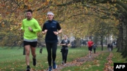People exercise in Green Park in central London on November 8, 2020 during a second national lockdown designed to contain soaring infections of the novel coronavirus. (Photo by DANIEL LEAL-OLIVAS / AFP)