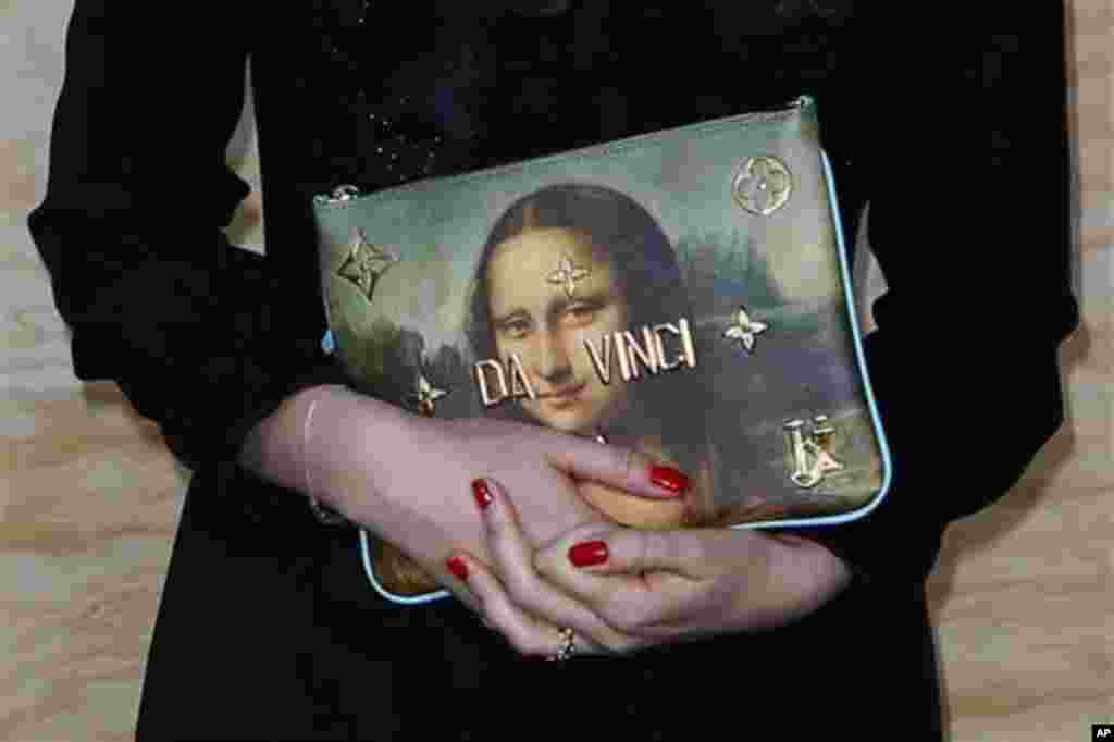 2017年4月11日，在罗浮宫博物馆的路易斯威登产品展示会上，该公司副总裁拿着印有名画蒙塔丽莎的手袋照相