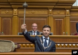 The new Ukrainian President Volodymyr Zelenskiy holds up a mace or "bulava," the Ukrainian symbol of power, during his inauguration ceremony in Kyiv, Ukraine, May 20, 2019.