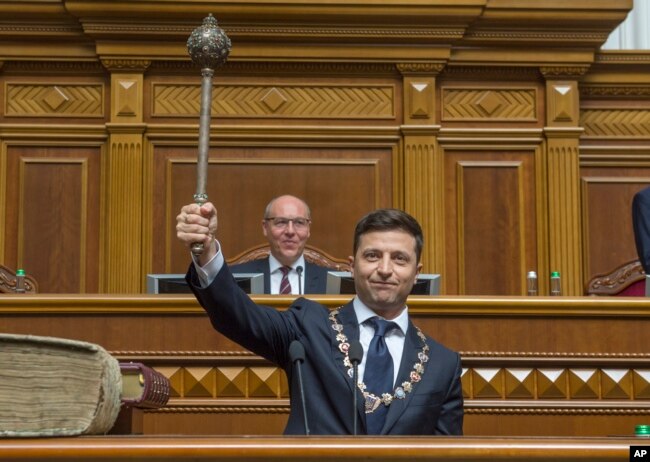 The new Ukrainian President Volodymyr Zelenskiy holds up a mace or "bulava," the Ukrainian symbol of power, during his inauguration ceremony in Kyiv, Ukraine, May 20, 2019.