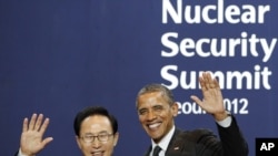 South Korea's President Lee Myung-bak (L) poses with U.S. President Barack Obama as he arrives for a working dinner at the Nuclear Security Summit at the Convention and Exhibition Center in Seoul, March 26, 2012.