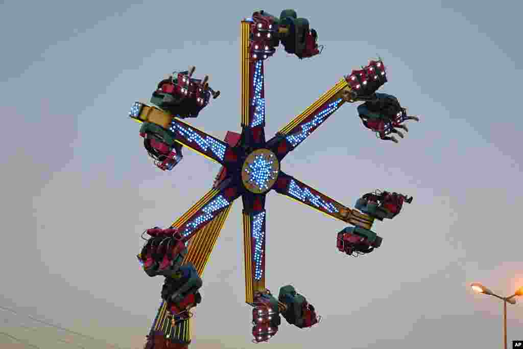 People enjoy a ride at an amusement park during Eid al- Fitr celebrations, that mark the end of the Muslim holy fasting month of Ramadan, in Baghdad, Iraq, June 16, 2018.