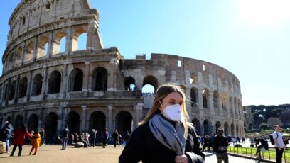 Du khách mang khẩu trang bên ngoài thắng cảnh the Colosseo ở Rome ngày 28/2/2020 giữa dịch Covid-19. (Photo by Andreas SOLARO / AFP)