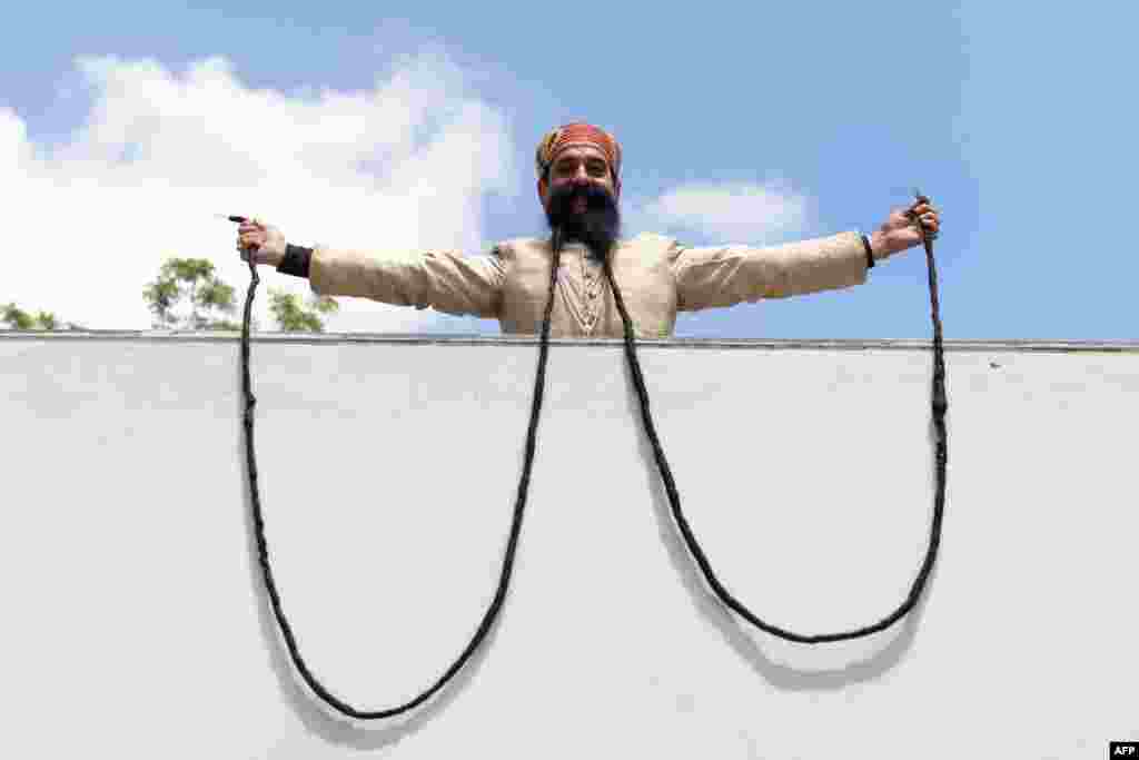 Ram Singh Chauhan (61) displays his approximately 18 foot long moustache in Ahmedabad, India.