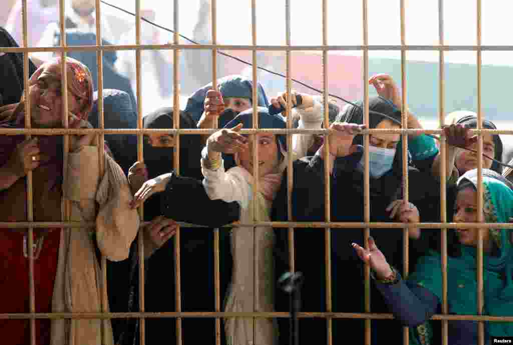 Women wait to receive tokens needed to apply for a Pakistani visa in Jalalabad, Afghanistan.